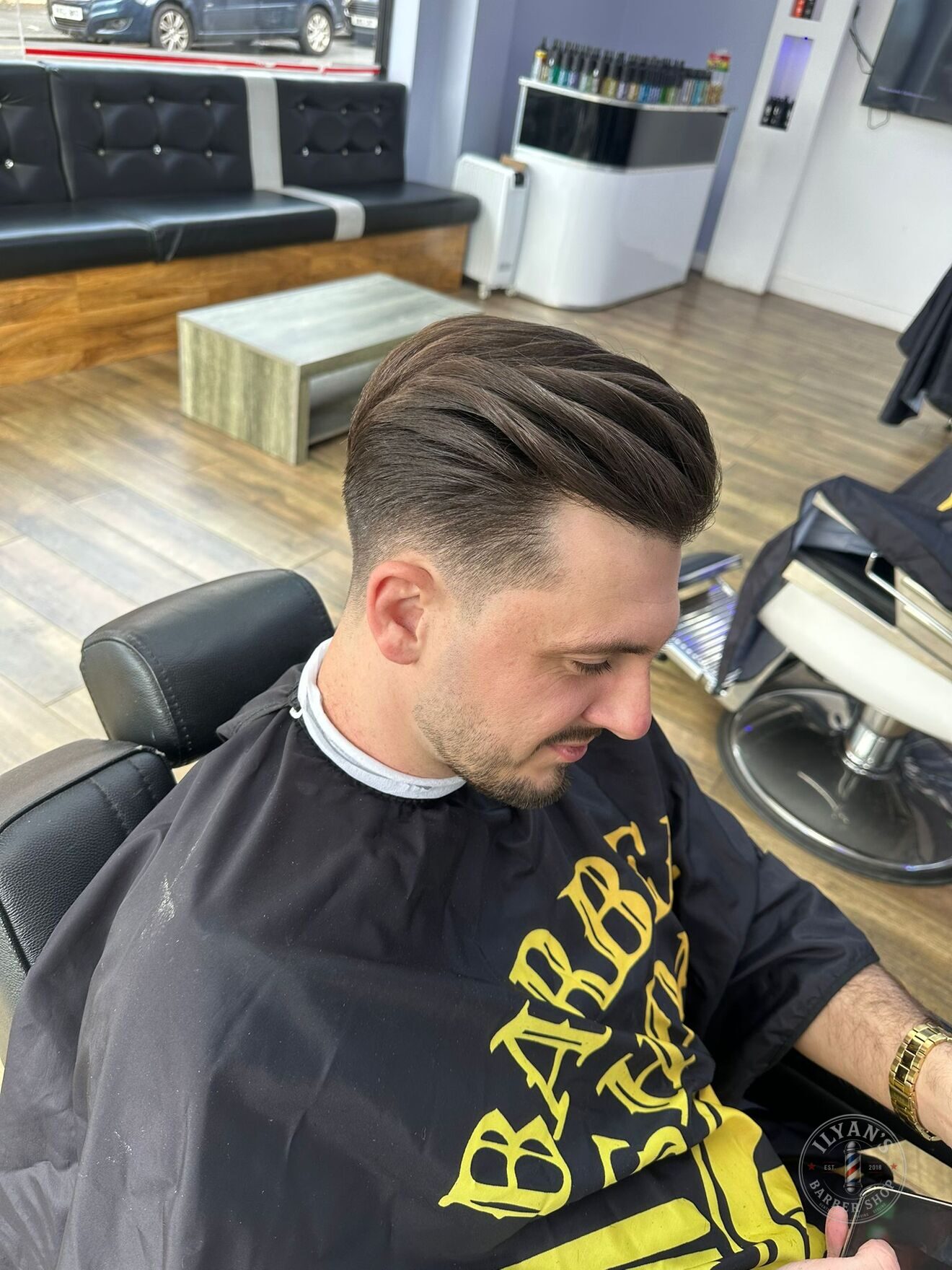 A comb over with a low taper fade at Ilyan's Barber Shop